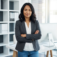 A woman standing in her office with her arms crossed.
